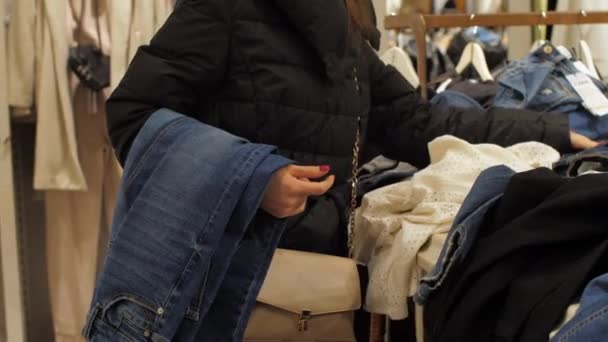 Comprador profissional segura jeans jeans jeans e toca roupas — Vídeo de Stock