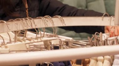 Beyaz destekli farklı giysileri olan kişi askıları taşır