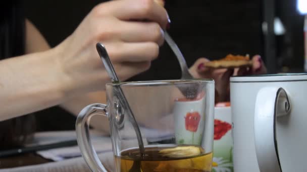 Üzletasszony kekszet eszik lekvárral az asztalnál ülve teával. — Stock videók
