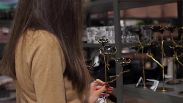 Profesionální designér se dotýká černého a zlatého svícnu — Stock video