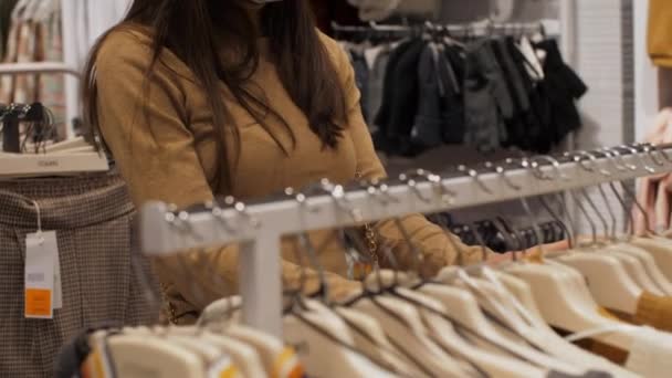 A nő keresi a gyapjú pulóver méretét és színét — Stock videók
