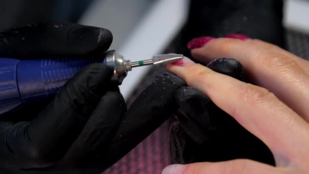 黒手袋の熟練した美容師は赤マニキュアを処理します — ストック動画