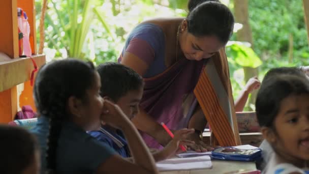 Lankan schooljuf corrigeert fouten in papieren notitieboekje — Stockvideo