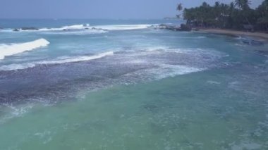 Sarı sahil şeridinde köpüklü okyanus dalgaları