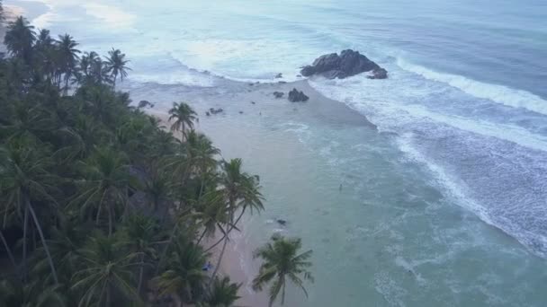 Agua azul del océano con espuma blanca en la costa con palmeras — Vídeo de stock