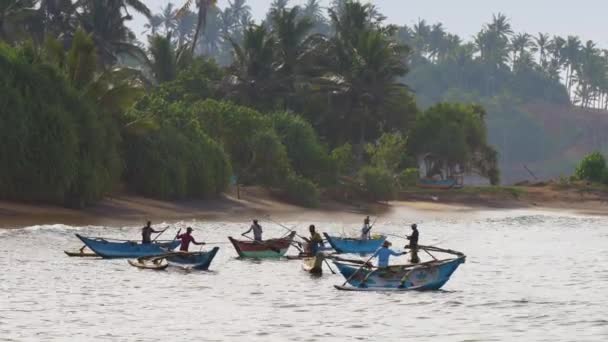 Fishermen balance on rowing boats on azure ocean waves — Stock Video