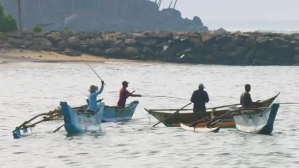 Grupo de pescadores asiáticos con equilibrio de cañas en barcos cerca del muelle — Vídeo de stock