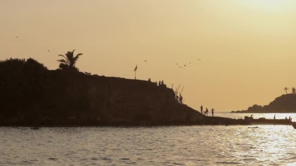 海のビーチやボートに丘を下る人々のシルエット — ストック動画