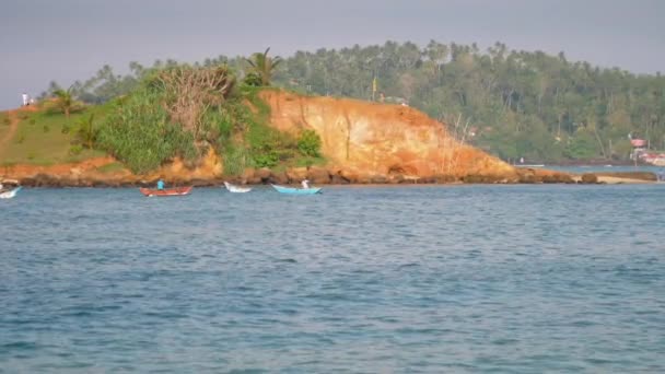Łodzie przepływają przez bezkresne błękitne morze na stromym zboczu — Wideo stockowe