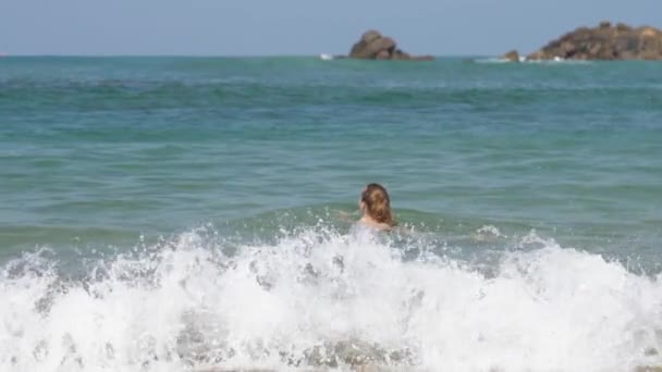 Жінка з булочкою з волоссям любить плавати в яскравому тропічному морі — стокове відео