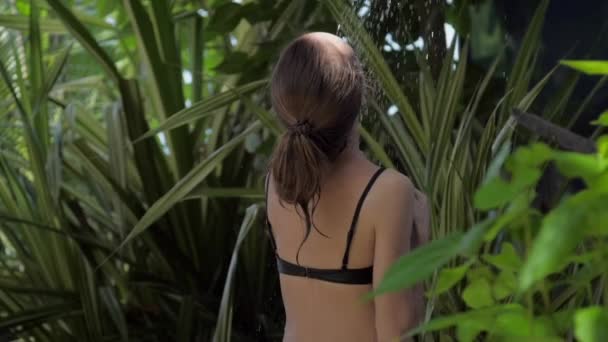 Femme mince aime douche tropicale rafraîchissante dans la forêt — Video