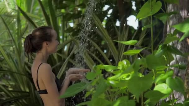 Agradable mujer disfruta fuera ducha contra la flora tropical — Vídeo de stock