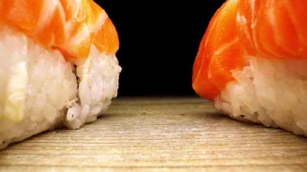 Läcker sushi med ris och röd fisk står på brunt ombord — Stockvideo