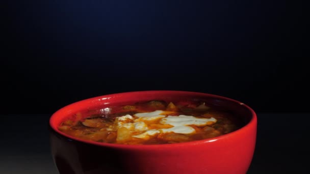 Sopa de colonos con crema agria blanca gira en tazón rojo — Vídeos de Stock