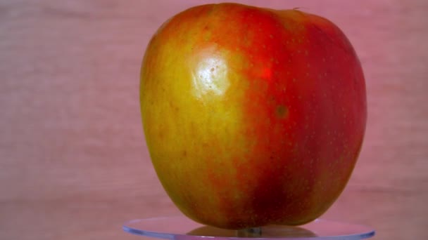Świeże czerwone żółte jabłko odbija jasne światło elektryczne — Wideo stockowe