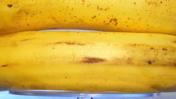 Oude bananen met gele schillen en bruine vlekken draaien rond — Stockvideo