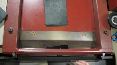 Yaşlı terzi, deri dilimleri sıralanmış tezgahlarda hareket ettiriyor.