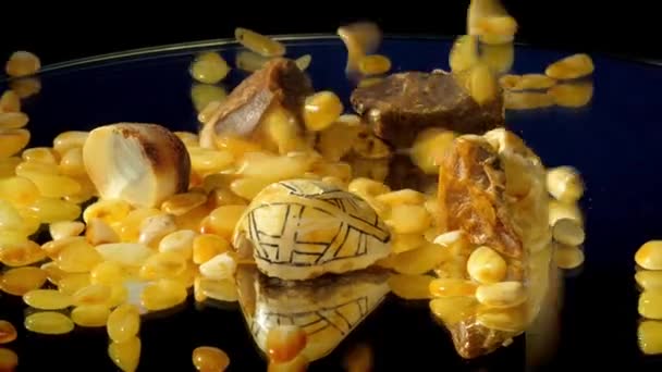 Small polished amber stones fall near different gemstones — Stock Video