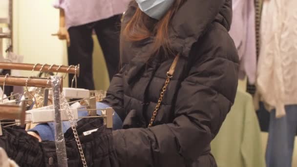 Lady regarde élégant jeans en denim bleu sur cintres en magasin — Video