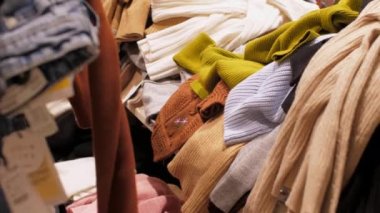 Manikürlü alışveriş merkezi ziyaretçisi kahverengi kazağı alır.