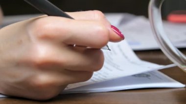 Manikürlü tezgahtar elleri kontrat formlarını doldurur.