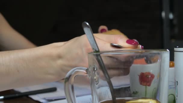 Brune aux cheveux longs met de la confiture jaune sur cookie avec cuillère — Video