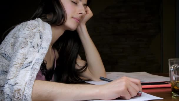 Estudiante de pelo largo con siestas de pluma sosteniendo la cabeza en la mano — Vídeos de Stock