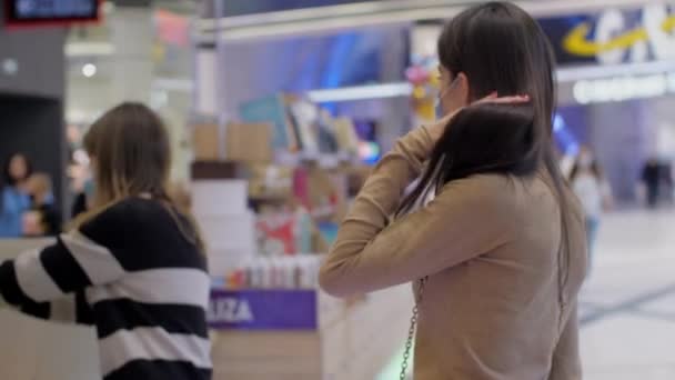 Morena de pelo largo en mascarilla desechable mira a su alrededor — Vídeos de Stock