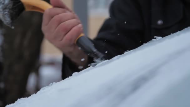A személy jégkaparóval tisztítja az elektromos autó szélvédőjét — Stock videók