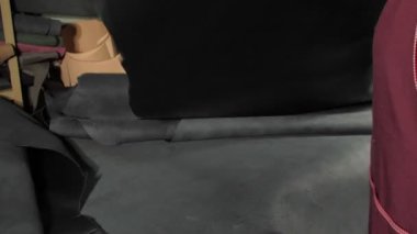 Yetenekli terzi elinde büyük siyah deri rulo vidaladı.