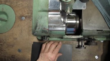 Eski terzi elleri siyah deri cüzdan ögeleri dikiyor.