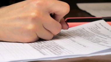 Manikürlü bir yönetici. Kağıt formunu kalemle dolduruyor.