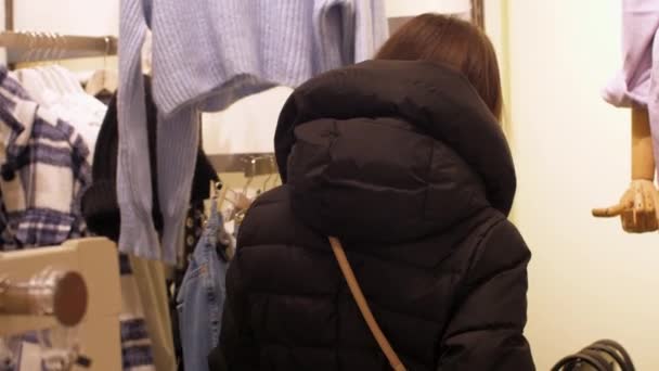 Lady regarde élégant jeans en denim bleu sur cintres en magasin — Video