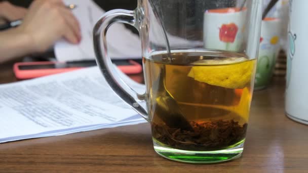 Zwarte thee met citroen in beker tegen zakenvrouw thuis — Stockvideo