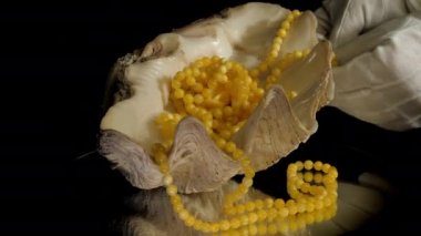 Mücevher koleksiyoncusu sarı kehribar tespih numunesini tamir ediyor.