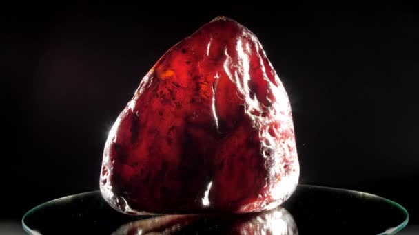 Kostbare rode amber steen van vreemde vorm ligt close-up — Stockvideo