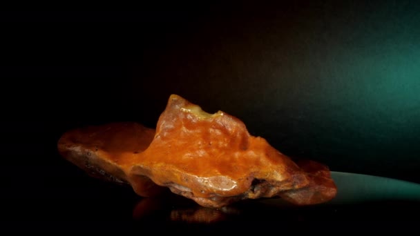 Sárga borostyán kő furcsa formában fekszik az üveg alátámasztására — Stock videók