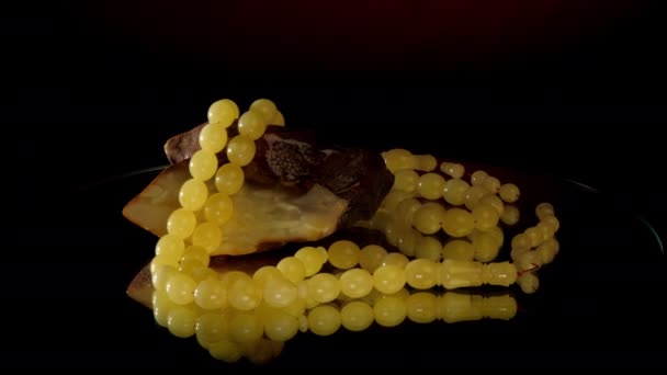 Witte matte amber rozenkrans in de buurt van grote vuile edelsteen closeup — Stockvideo