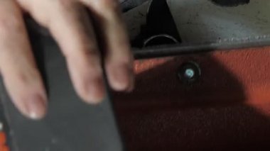 Yaşlı terzi kumaştan arta kalan küçük deri elementleri kesiyor.