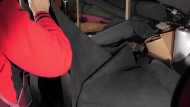 Arbeiterin in der Lederherstellung nimmt schwarzen Stoff — Stockvideo