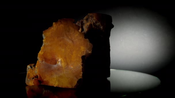 Grote gebroken gele edelsteen draait op glasdrager — Stockvideo
