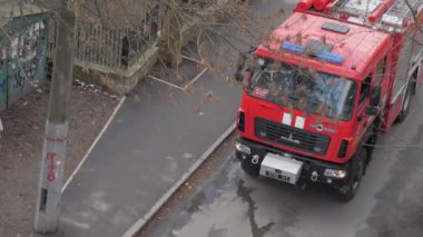Şehir caddesi boyunca yeni kırmızı itfaiye aracı sürüyor.