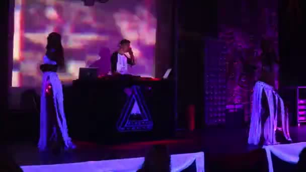 Dansatori în costume strălucitoare dansează la consola DJ din club — Videoclip de stoc