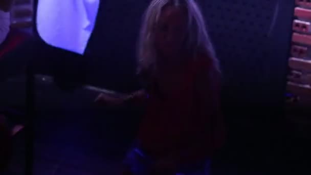 Blondynka dziewczyna tańczy do nowoczesnej muzyki w nocnym klubie — Wideo stockowe
