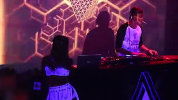 Девушка в белом топе с приставкой ди-джей в ночном клубе — стоковое видео