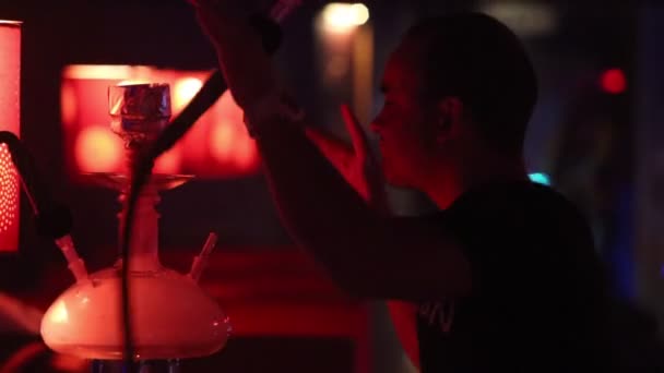 Cara fuma narguilé e dança a música no clube — Vídeo de Stock