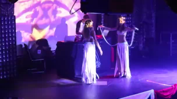 Jenter i hvite, glødende showkostymer danser nær Dj på scenen – stockvideo