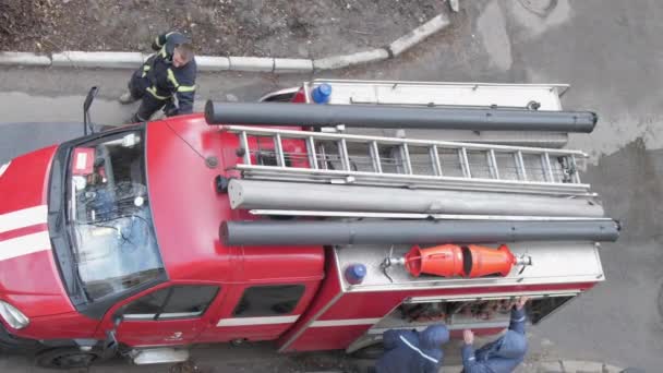 Bombeiros profissionais reúnem equipamentos no motor de incêndio — Vídeo de Stock