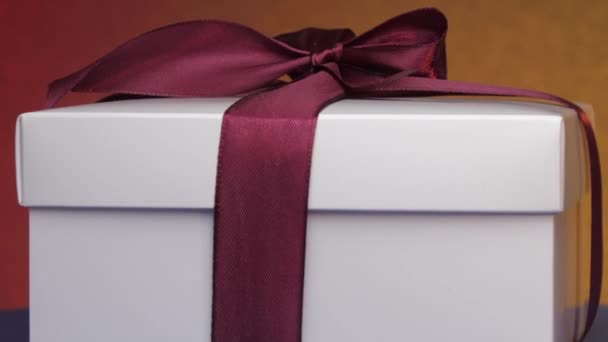 Caixa de papelão presente branco com fita roxa e arco — Vídeo de Stock