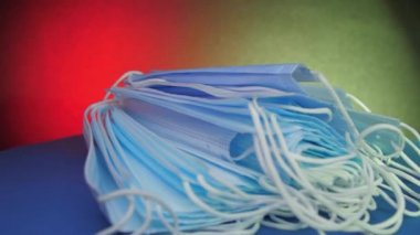 Mavi tek kullanımlık maskeler masanın üzerinde, elektrik ışığının altında.